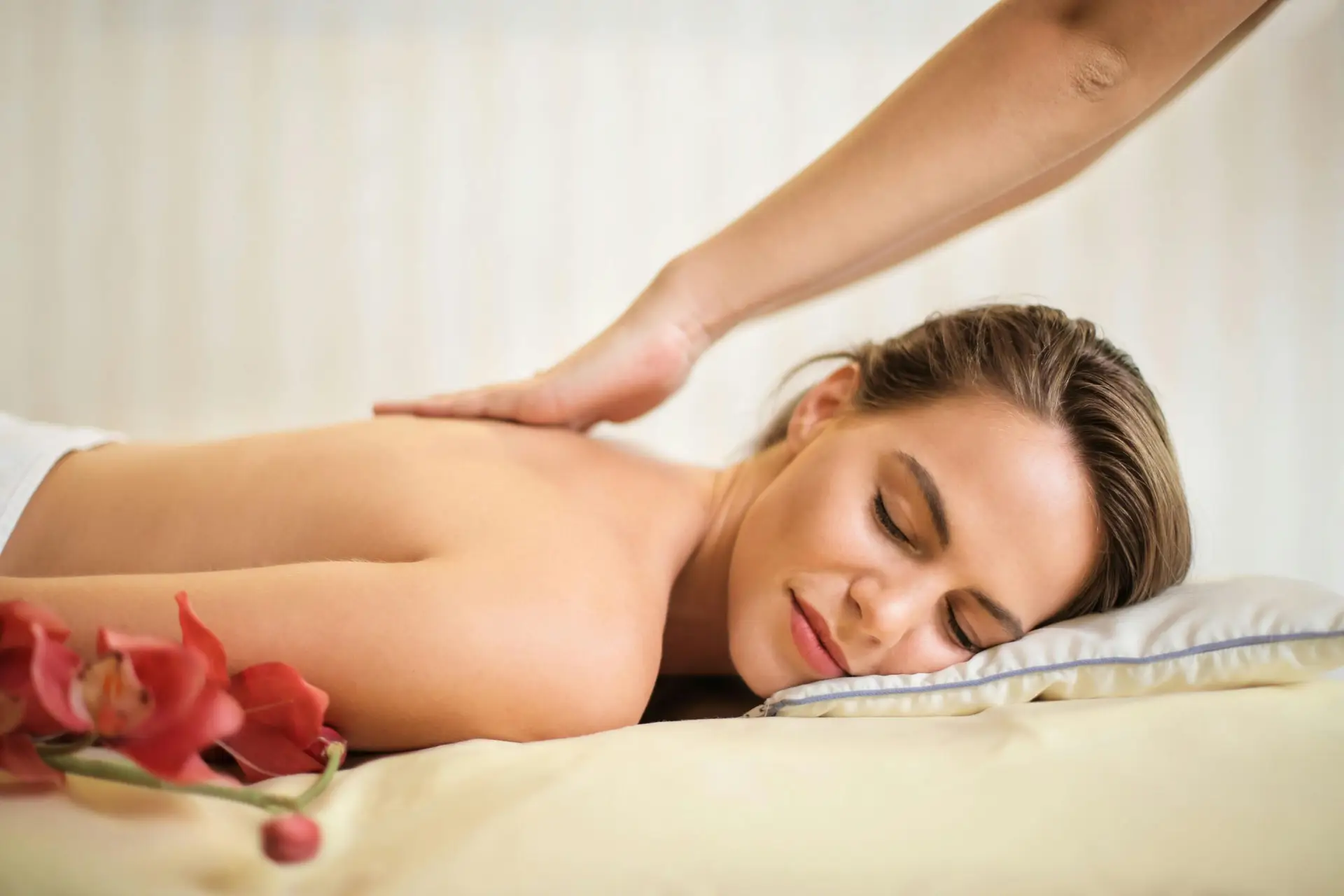 A serene spa scene featuring a woman receiving a therapeutic massage, surrounded by soothing elements.